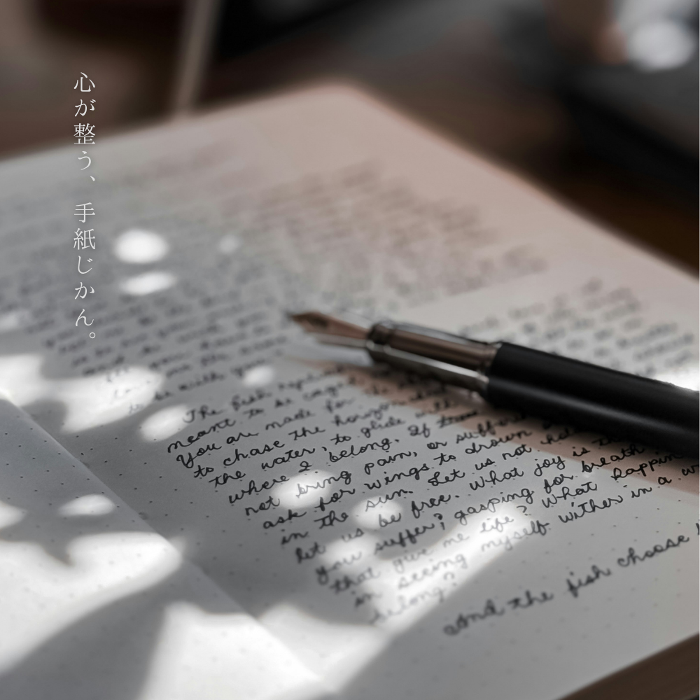 びっしりと文字が書かれた便箋に転がる万年筆。木洩れ日の日が影を落としている